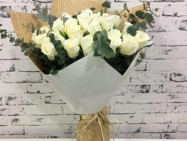Buchet frumos de trandafiri albi și eucalipt în hârtie kraft de ziar - Foto
