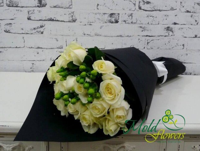 Букет из белых роз и зеленого гиперикума в черной бумаге с белой лентой фото
