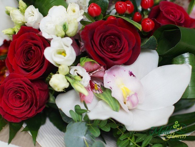 Букет из красных роз, гиперикума, белых, розовых альстомерий и орхидей, белых эустом, и эвкалипта в желтой бумаге фото