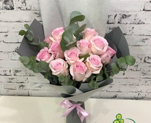 Bouquet of pink roses and eucalyptus in gray paper photo