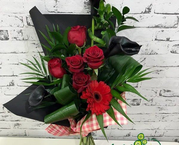 Букет из красных роз и гербер, черных калл, аспидистры в черной бумаге фото