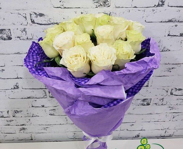 Bouquet of white roses in purple paper photo