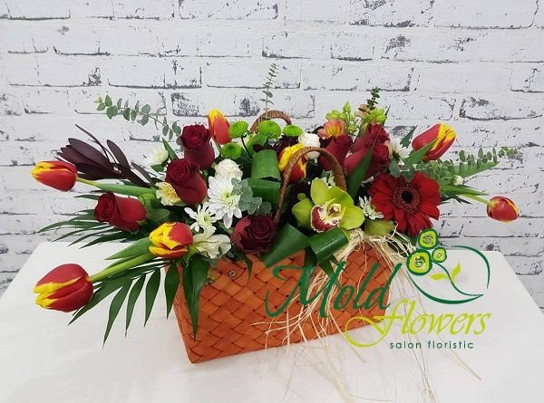Handbag with yellow and red tulips, red roses and gerberas, green orchids and chrysanthemums, white chrysanthemums photo