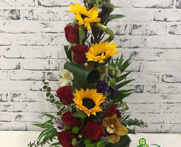 Composition of sunflowers, red roses, purple eustomas, white alstromeria, green and purple chrysanthemums, leucodendron photo