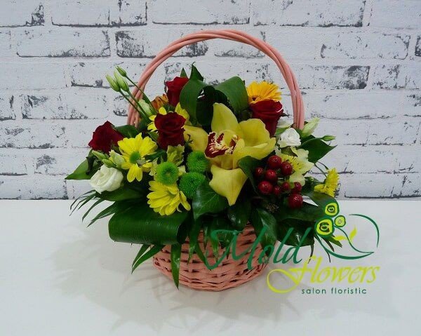 Pink basket with yellow orchids, chrysanthemums, gerberas, red roses and hypericum, green chrysanthemums photo