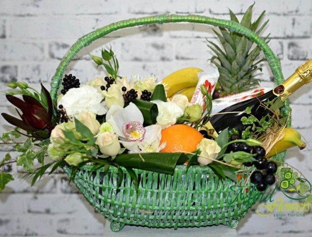 A large green basket with fruit and champagne photo