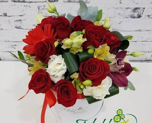 White box with red roses, gerbera, white eustomas, yellow alstromeria, purple orchid, aspidistra photo