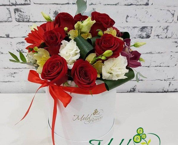 Белая коробка с красными розами, герберой, белыми эустомами, желтыми альстромериями, фиолетовой орхидеей, аспидистрой фото
