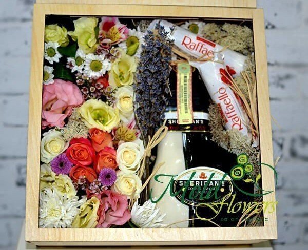 Composition in a wooden box with roses, chrysanthemum, eustoma, lavender, candies, bottle photo