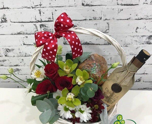 Basket with roses, chrysanthemums, cymbidium orchids, eustoma, alstromeria, eucalyptus, wine, Easter photo