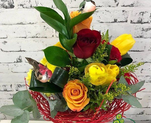 Букет в красном каркасе с желтыми тюльпанами, солидаго, красными розами, оранжевыми розами, эвкалиптом, декоративная птичка и гнездо фото