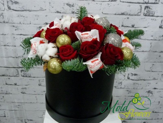 Black box with raffaello, red roses, Christmas toys, cotton, sprigs of spruce photo
