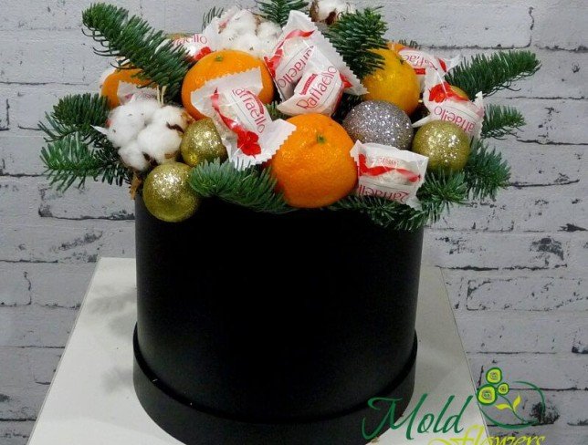 Черная коробка с конфетами Raffaello, мандаринами, новогодними игрушками, хлопком, еловыми ветками фото