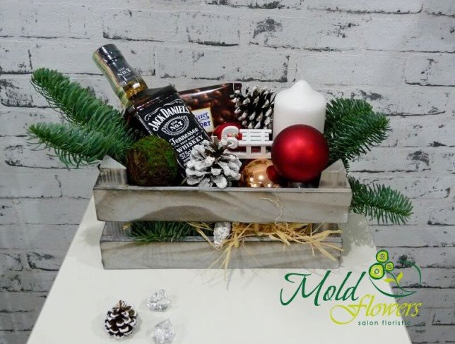 Деревянный ящик с веточками ели, бутылкой Jack Daniels, шоколад Ritter Sport, свечой, шишками, новогодними игрушками фото