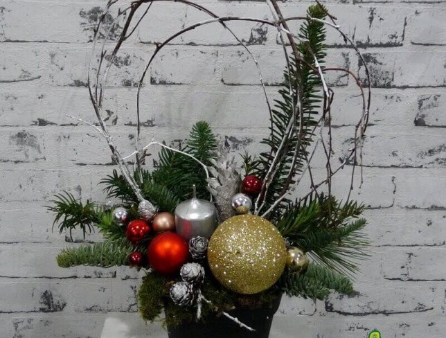 Composition in black pot with sprigs of spruce, cones, silver candle, Christmas toys photo