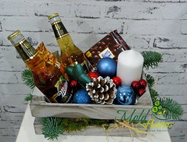 Wooden box with sprigs of spruce, pinecones, Miller bottles, chocolate, candle photo