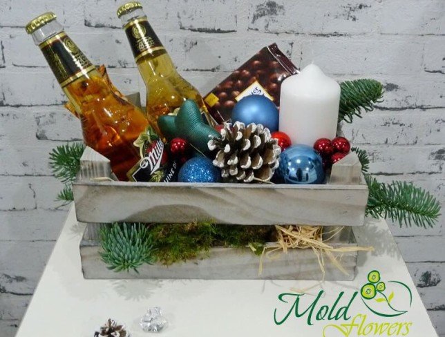 Wooden box with sprigs of spruce, pinecones, Miller bottles, chocolate, candle photo
