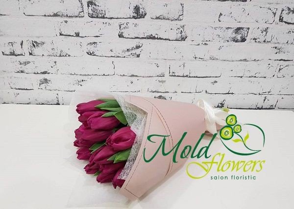 Bouquet of purple tulips in pink paper and white netting photo