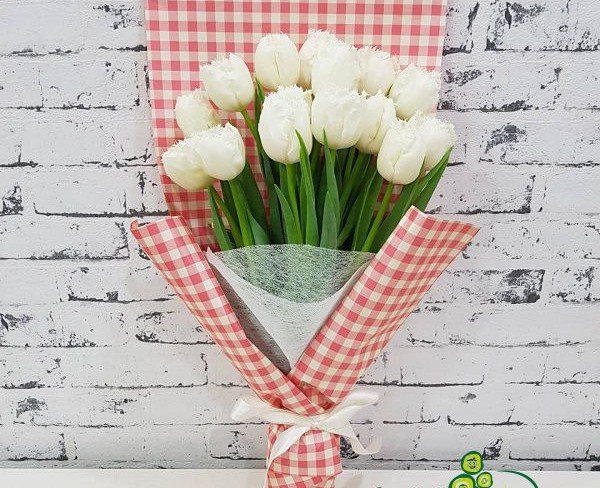 Букет в бело-красной обертке с белыми тюльпанами фото
