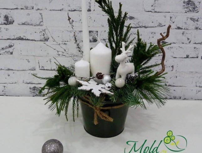 Composition in a bucket with white candles, decorative reindeer, snowflake, Christmas toys, cones photo