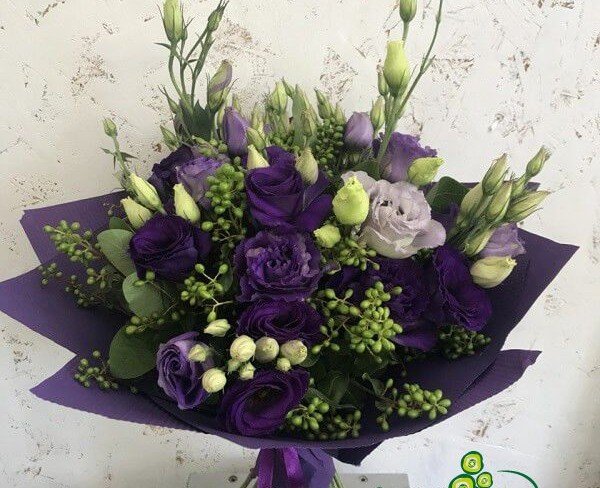 Bouquet of purple eustomas in purple paper photo