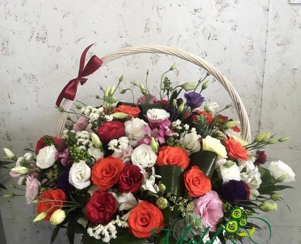 Basket with red and orange roses, white eustoma, statice, purple eustoma, pink alstromeria photo