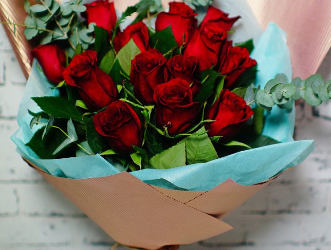 Bouquet of red roses in pink and blue paper photo
