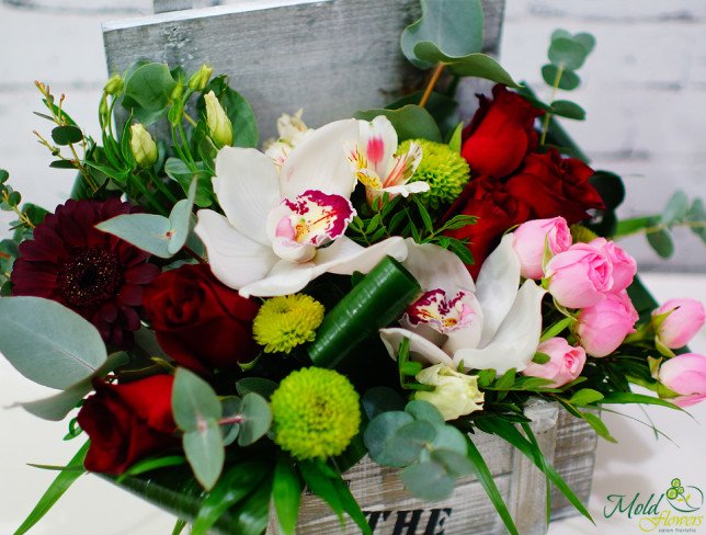 Box with red roses, gerbera, white orchids, eustomas green chrysanthemums, pink small flowers photo