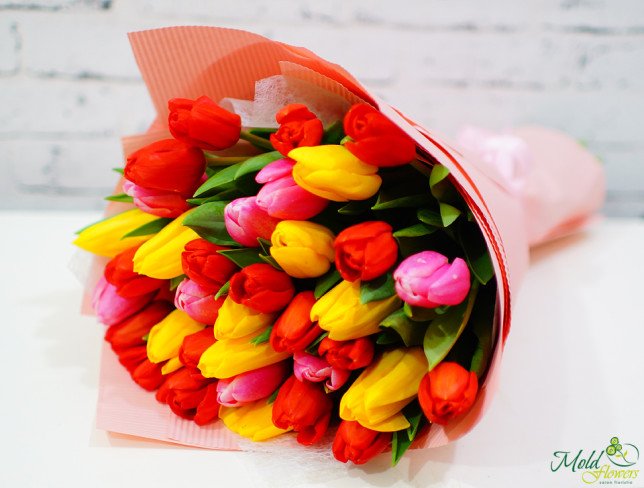 Bouquet of red, yellow, pink tulips in pink wrapping photo