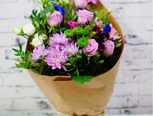 Букет из фиолетовых роз, ирисов, хризантем, розовых и белых эустом, зеленых хризантем в крафт бумаге фото