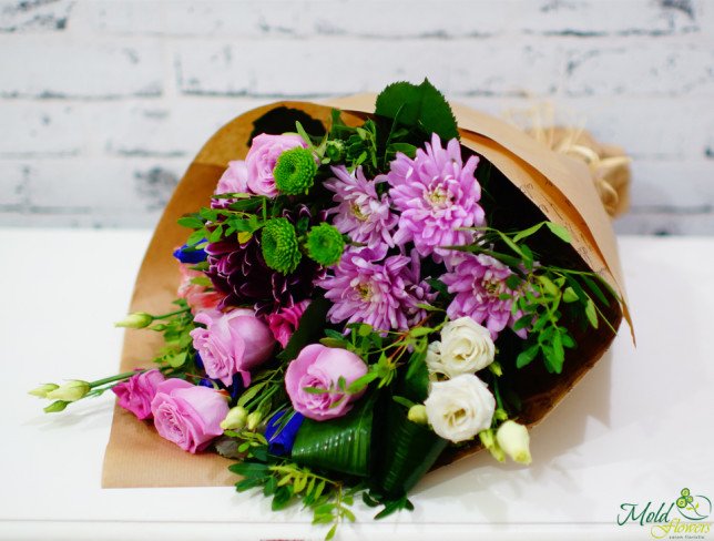 Bouquet of purple roses, irises, chrysanthemums, pink and white eustomas, green chrysanthemums in kraft paper photo