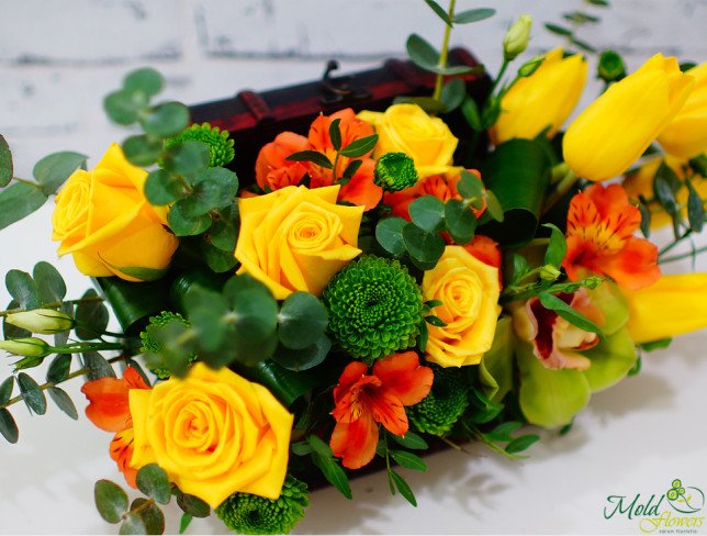 Chest with yellow tulips, roses, orchid, orange alstromeria, green chrysanthemum, eucalyptus photo