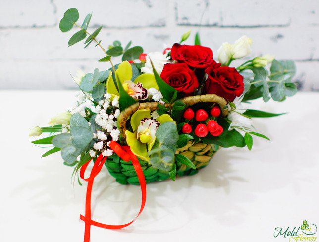 Basket with red and white roses, green orchids, red hypericum, eucalyptus photo