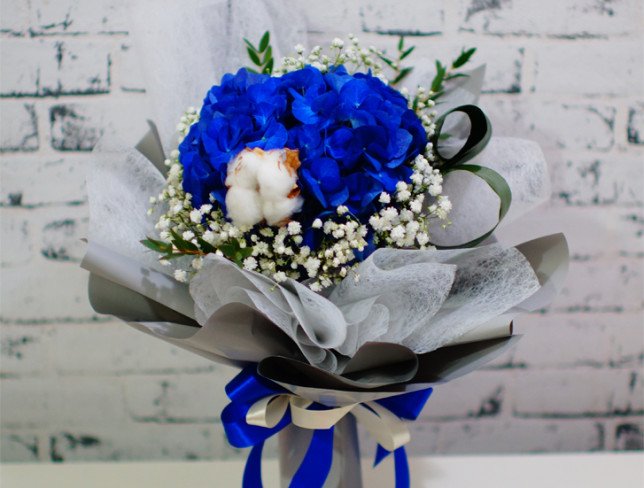 Bouquet of blue hydrangeas, white gypsophila, cotton, aspidistra, pistachios photo