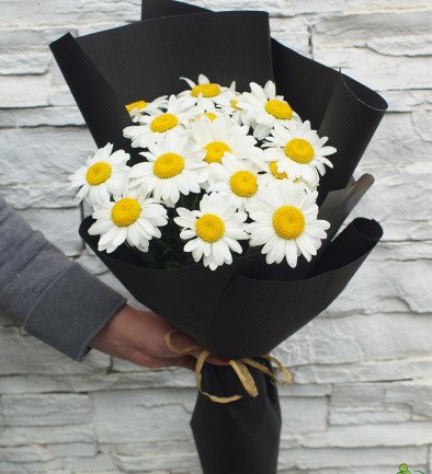 Bouquet of chamomile flowers in black paper photo 394x433