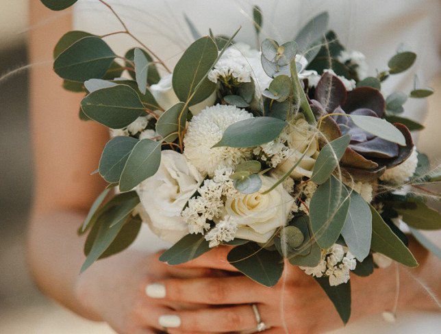 The bride's bouquet made of white rose, lisianthus, eucalyptus, and stone rose photo