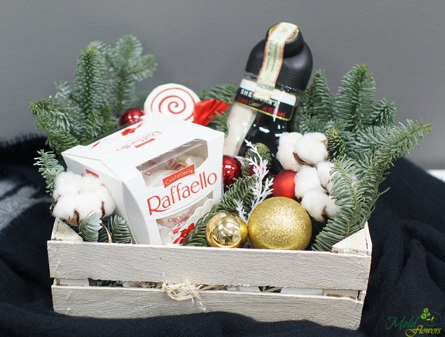 Wooden box with candy, Sheridans bottle, pinecones, Christmas toys, spruce branches photo