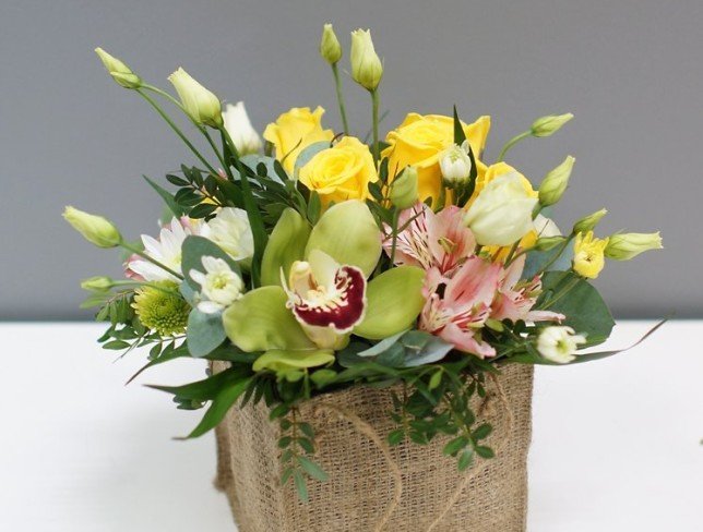 Burlap bag with roses, chrysanthemums, eustoma, alstroemeria and cymbidium orchid photo
