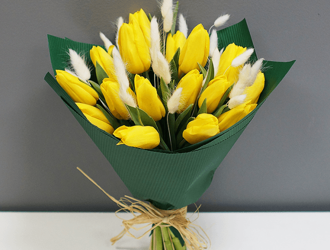 Bouquet of yellow tulips, spikelets in green paper photo