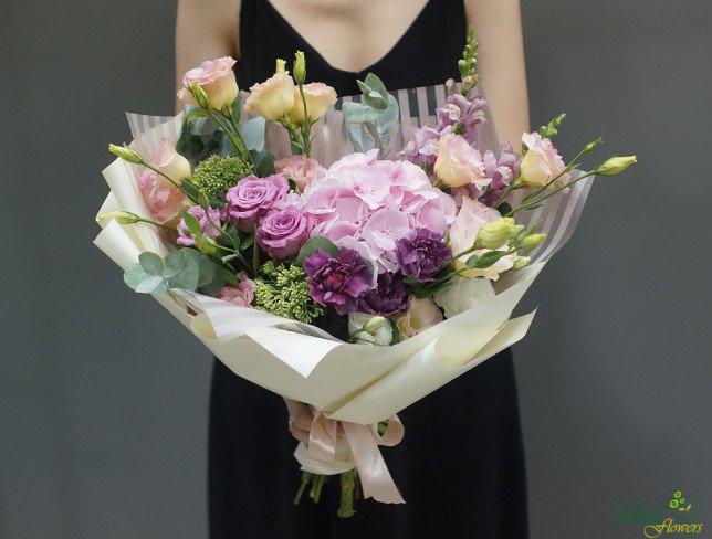 Bouquet with pink hydrangeas, purple roses, cream eustoma and purple carnations, in white paper