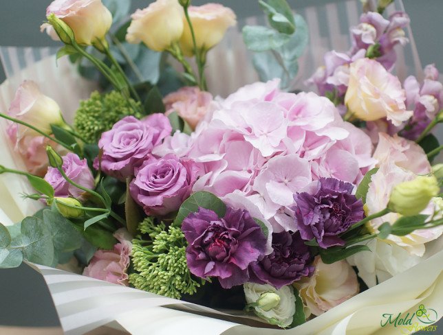 Bouquet with pink hydrangeas, purple roses, cream eustoma and purple carnations, in white paper