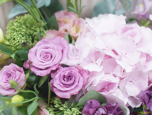 Bouquet with pink hydrangeas, purple roses, cream eustoma and purple carnations, in white paper