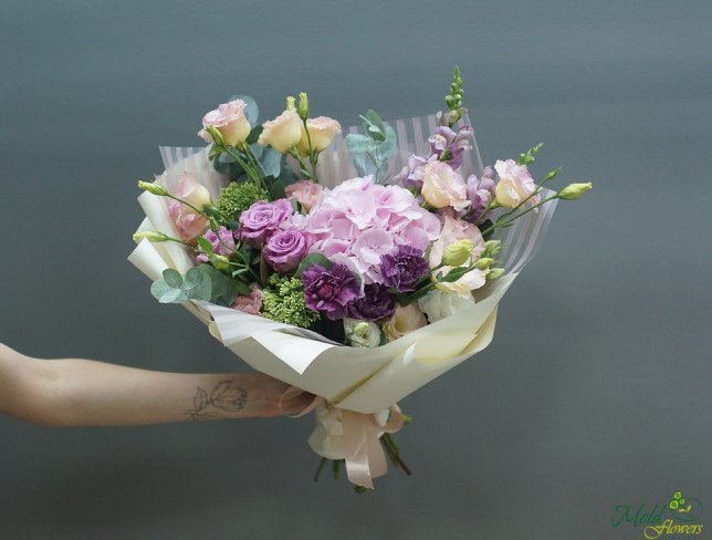 Bouquet with pink hydrangeas, purple roses, cream eustoma and purple carnations, in white paper