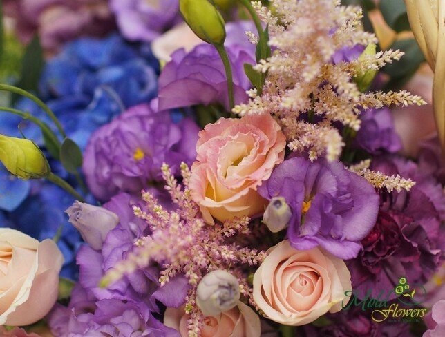Composition with blue hydrangeas, pale pink roses, purple eustoma and pink astilbe, in a natural basket