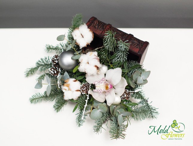 Chest with white orchid, cotton, eucalyptus, sprigs of spruce, pinecones and Christmas tree toys in silver color photo