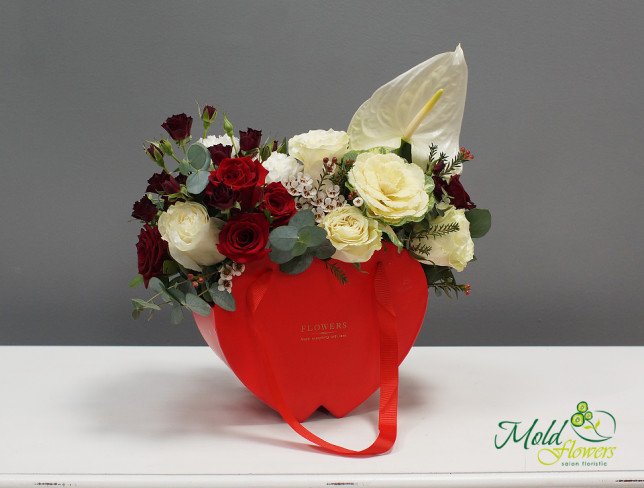 Composition with red roses, white anthuriums, and cream roses, decorated with greenery, arranged in a red box