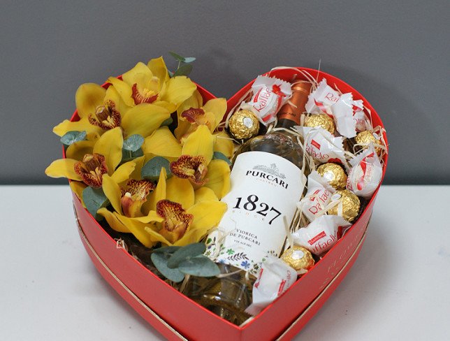 Heart box with yellow orchids, chocolates and white wine photo