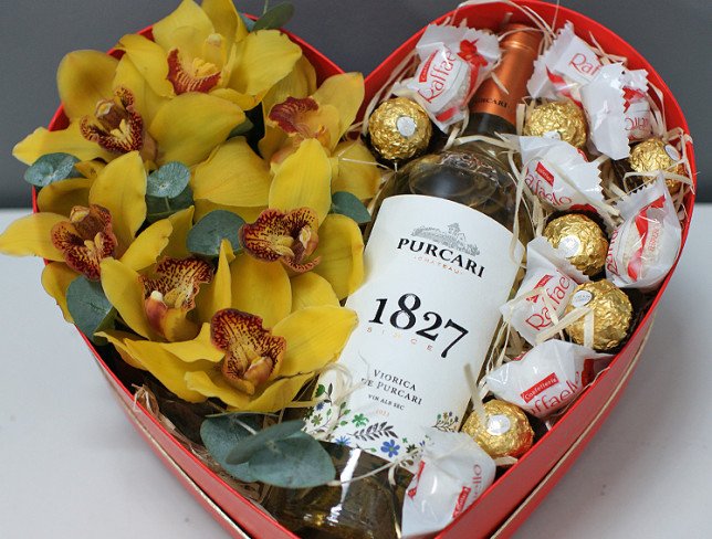 Heart box with yellow orchids, chocolates and white wine photo