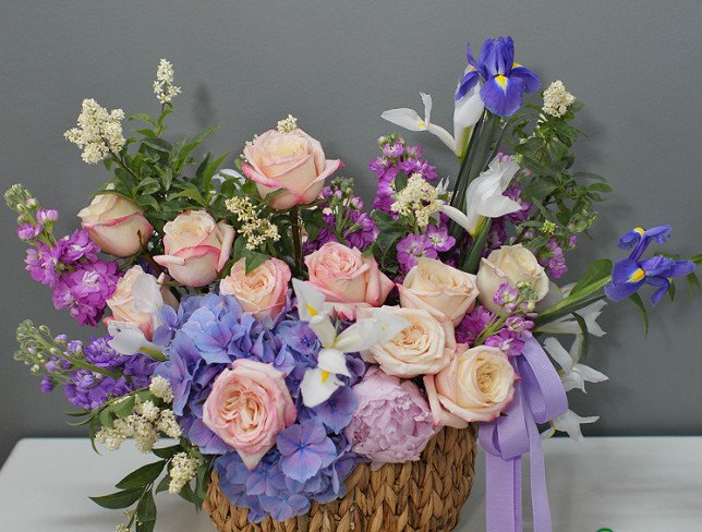 Wicker basket with purple hydrangea and roses photo