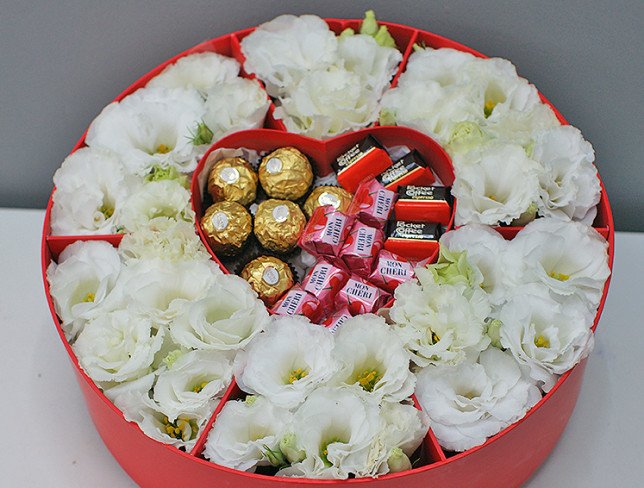 Box with white eustoma and sweets photo